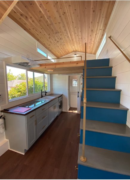 Exterior of a tiny home on wheels with a deck