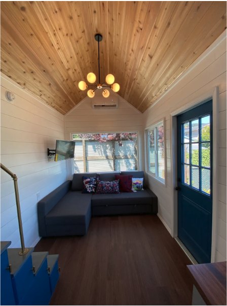 Living area inside a tiny home with a vaulted cedar ceiling